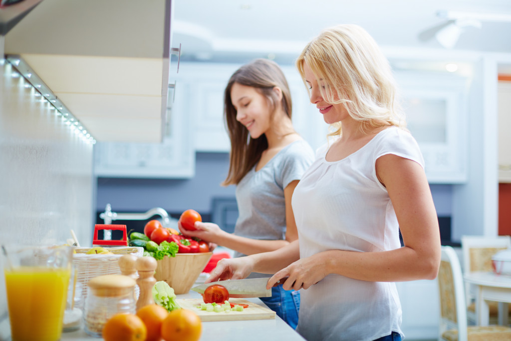 Portrait of happy mother and her daughter cooking in the kitchen